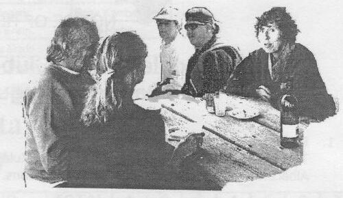 American visitors chatting around a picnic table with a wine bottle