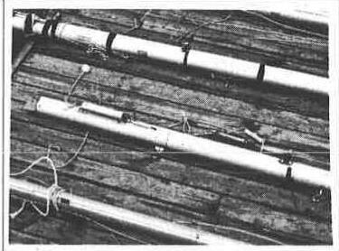 Albacore mast and boom sections lying on a wooden dock with their fittings and rigging attached