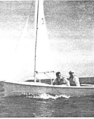 Two sailors hiking out on an Albacore sailing across choppy water
