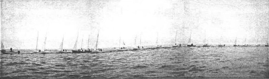 A long line of Albacores under tow, masts silhouetted against the sky