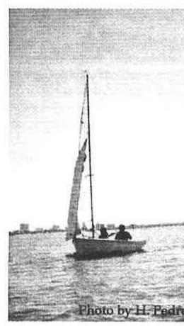 An Albacore with two crew sailing on flat water off Sarasota