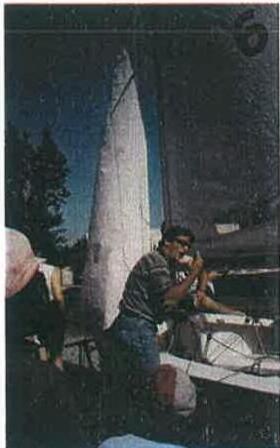 A sailor rigging an Albacore's mainsail