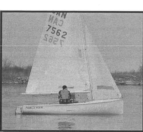 A solo Albacore, Pebbles Again, sailing away from the camera on calm water