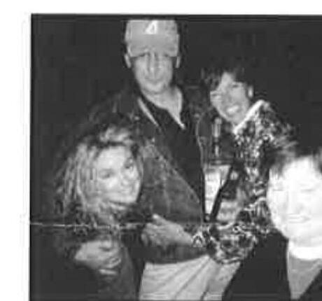 Four people laughing together at a nighttime club gathering