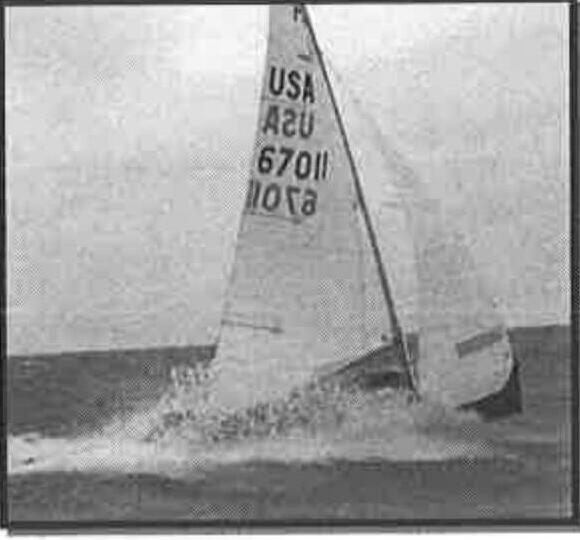 An Albacore planing hard with spray flying, main and jib both drawing