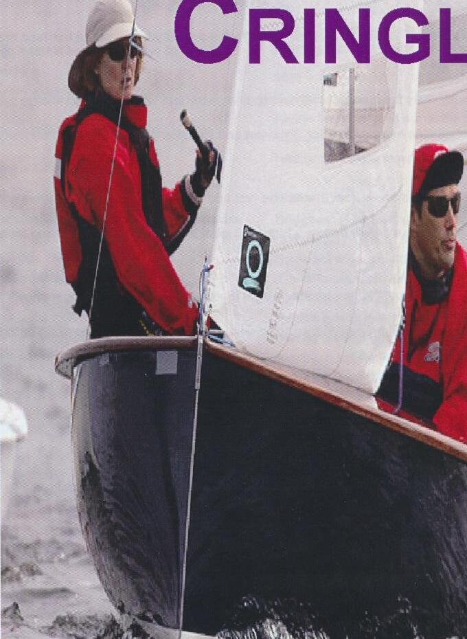 Two sailors, one in a red jacket, aboard an Albacore under sail