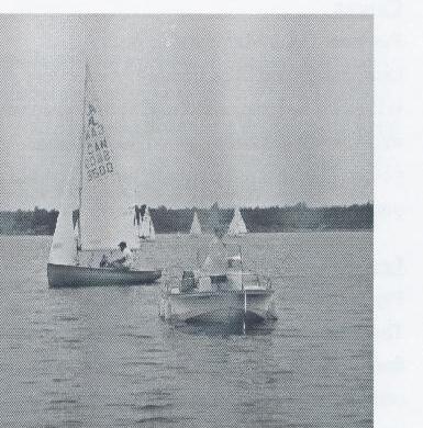Albacore fleet racing, one boat close in the foreground with a committee boat nearby