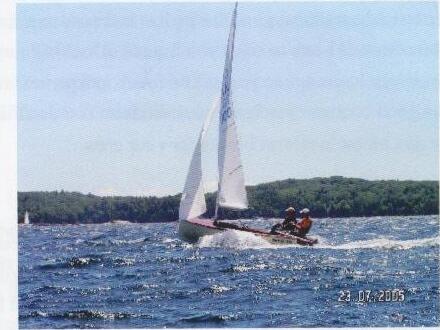 An Albacore planing on open water, two sailors aboard